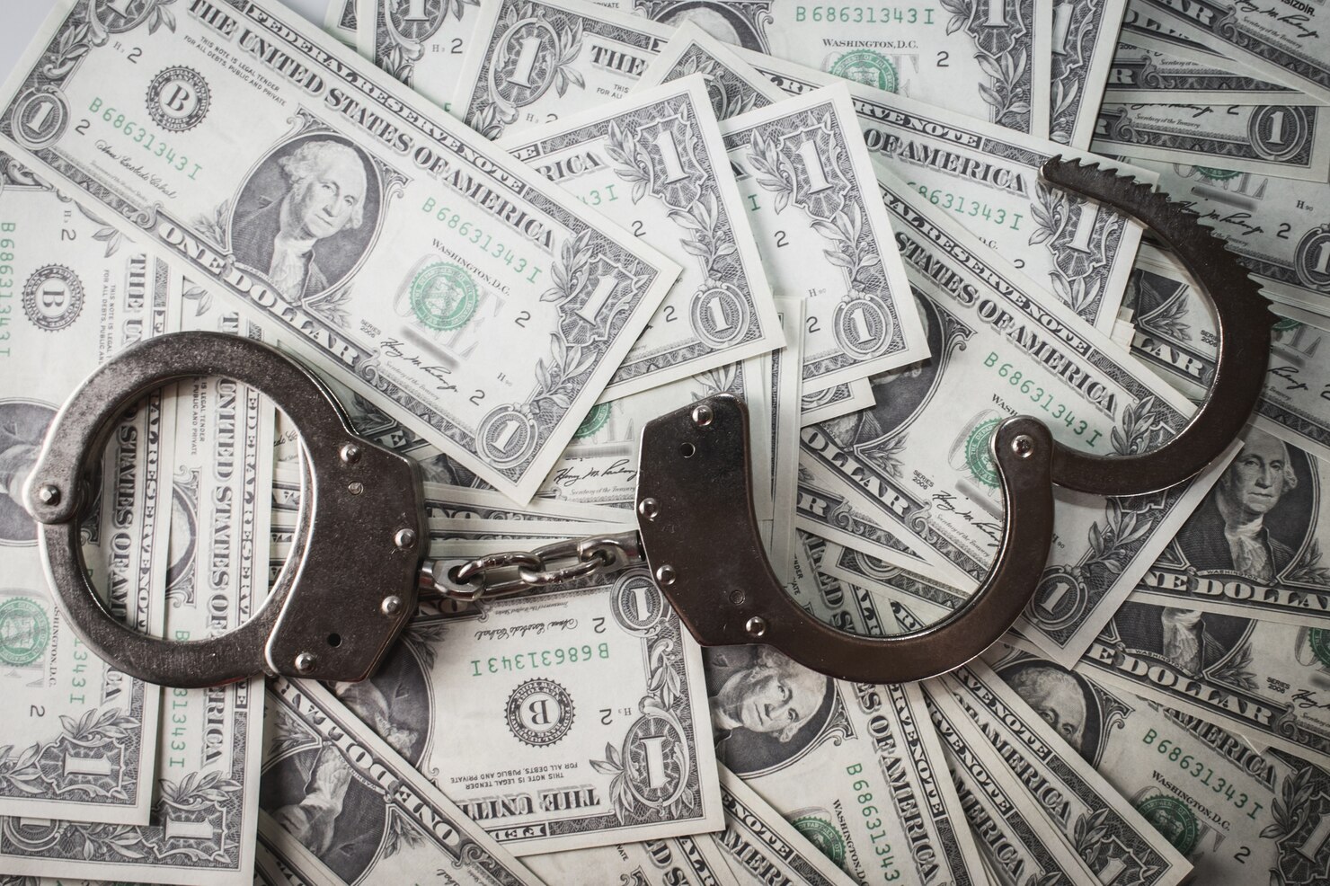 closeup-shot-metal-handcuffs-dollars_181624-27693.jpg